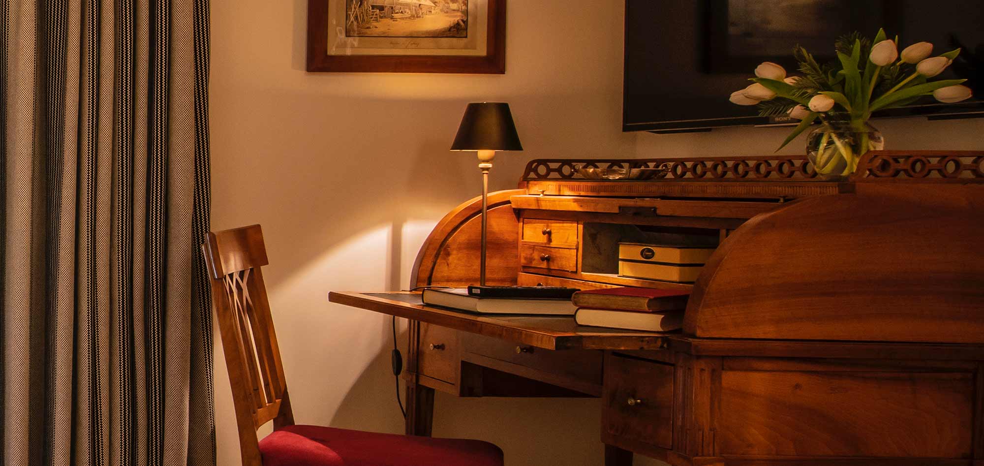 traditional style wooden desk with a vase of tulips