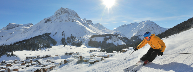 Skier down the slope with mountains in the background in Austria