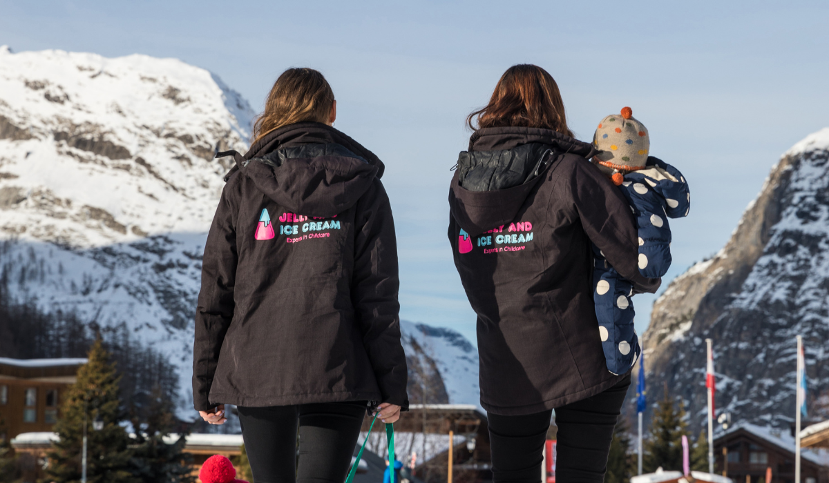 Childcare Team Looking After A Child At A Ski Resort