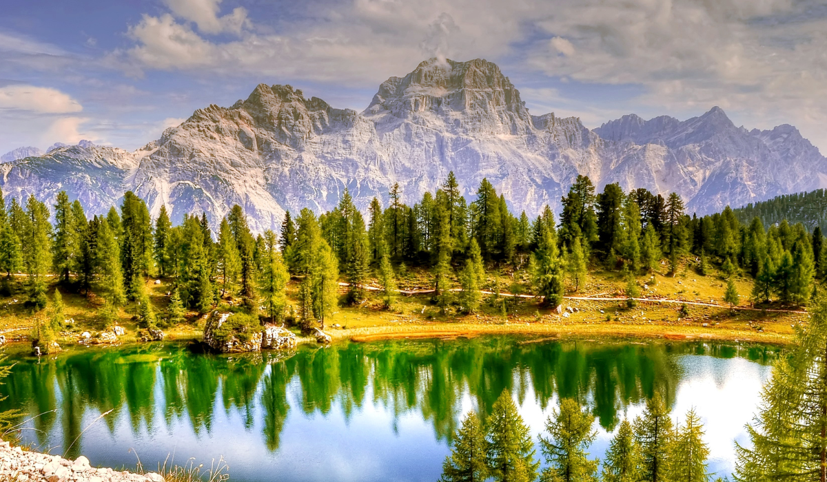 Dolomite mountains, blue lake and pine trees.