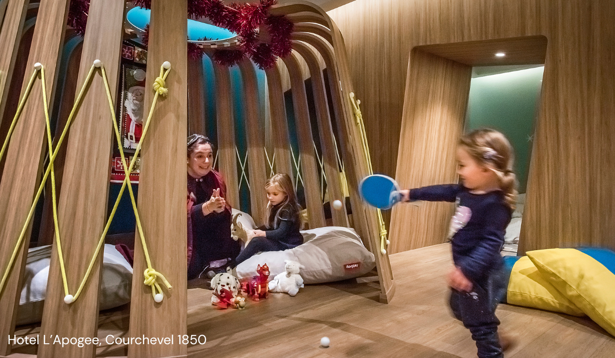 Hotel play room with two small children being entertained by a staff member. Picture attribution: Hotel Le K2 Palace, Courchevel 1850