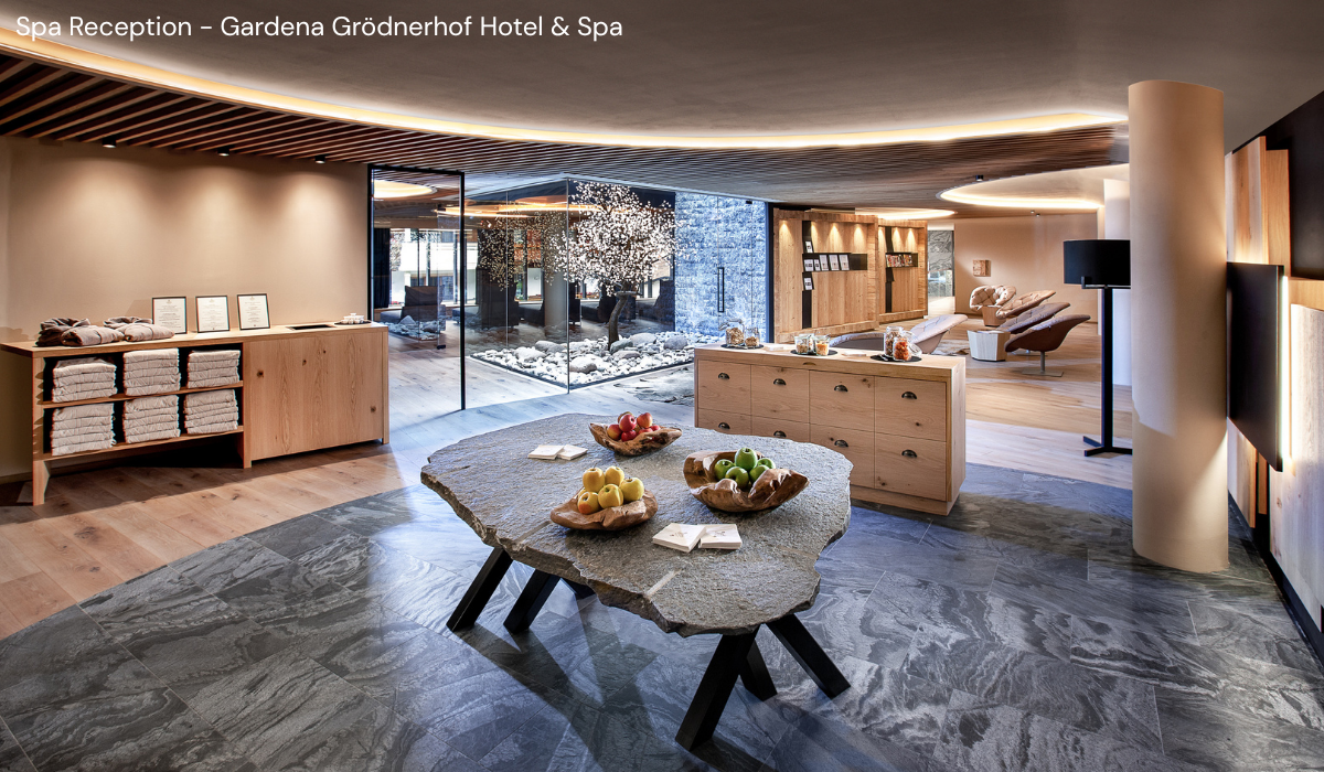 spacious and luxuriously lit foyer/reception space with fruit in bowl, towels folded on a side board.